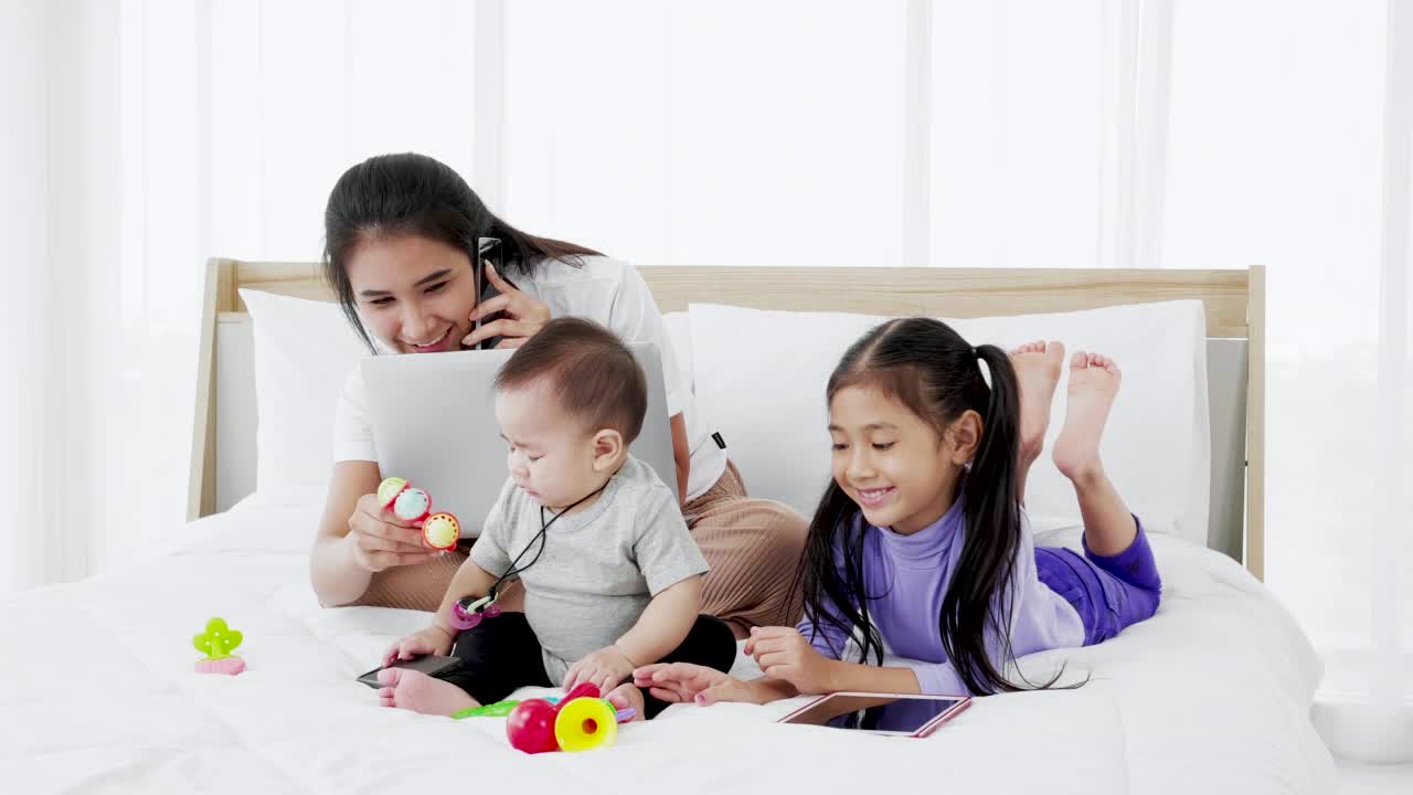 亚洲母亲与婴儿的女儿，女孩和婴儿使用笔记本电脑的家庭生活方式视频下载