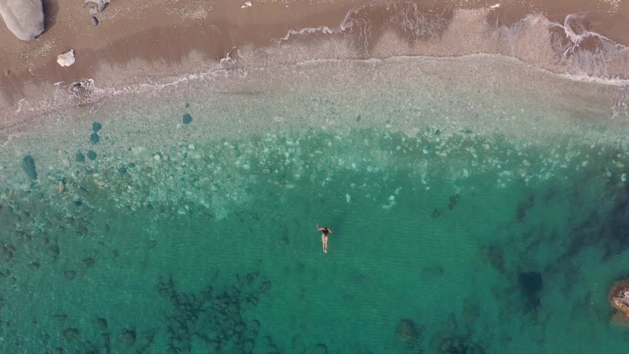鸟瞰漂浮在土耳其水晶般湛蓝的海水中的雌性视频素材