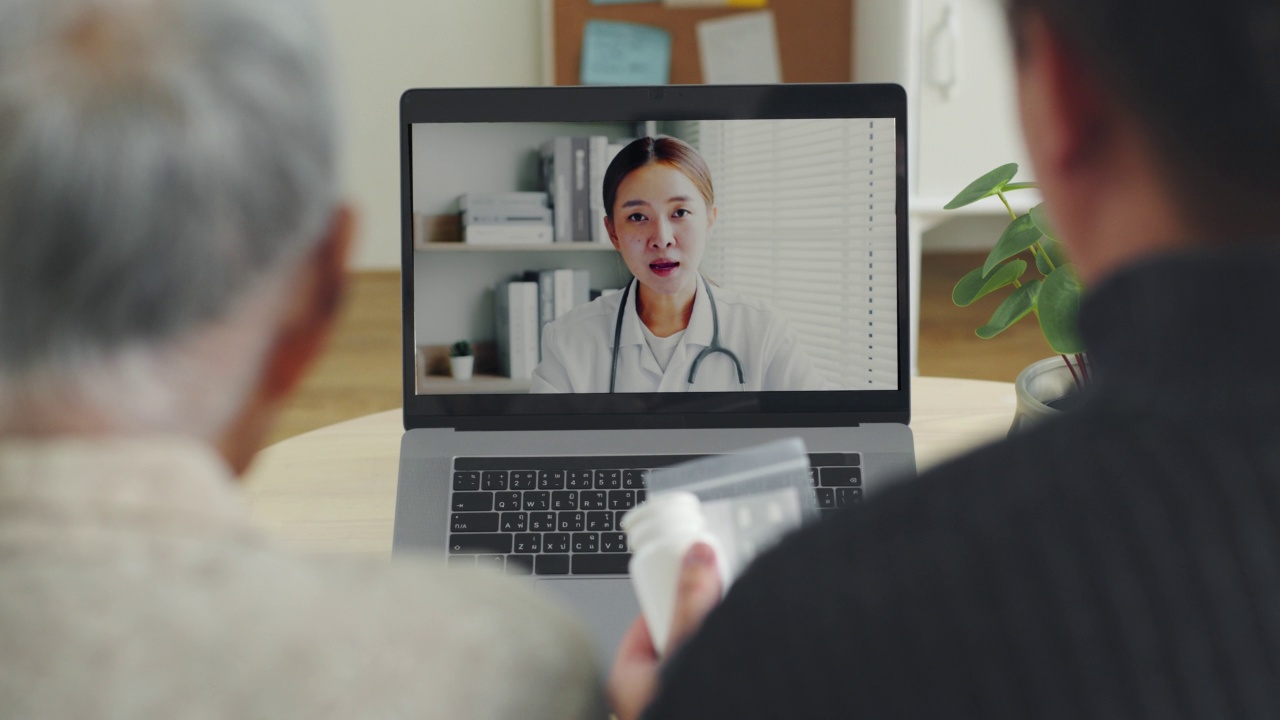 亚洲老年妇女灰白头发80-90年代视频电话与医生，远程医疗远程保健的概念视频素材