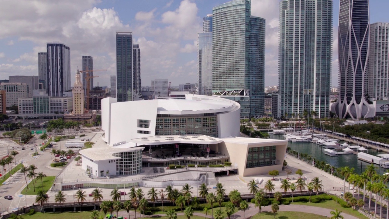 空中摇拍的Ftx竞技场的现代塔在城市，无人机在阳光明媚的日子在树上上升-迈阿密，佛罗里达视频下载