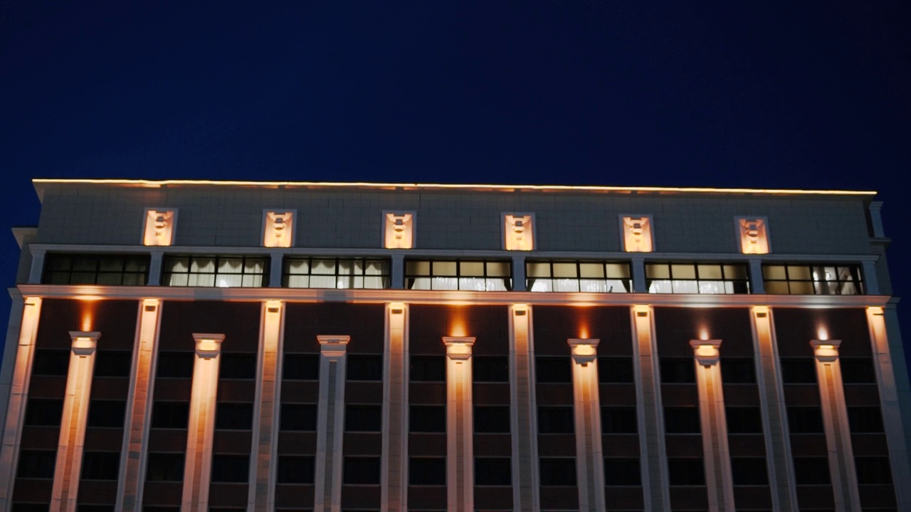 建筑外观的夜景，有橙色和白色的柱子照明视频下载