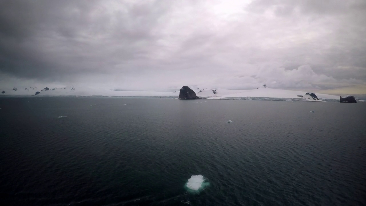 在多云的天空下被雪覆盖的山脉的观点时间流逝的海洋-南极半岛，南极洲视频素材