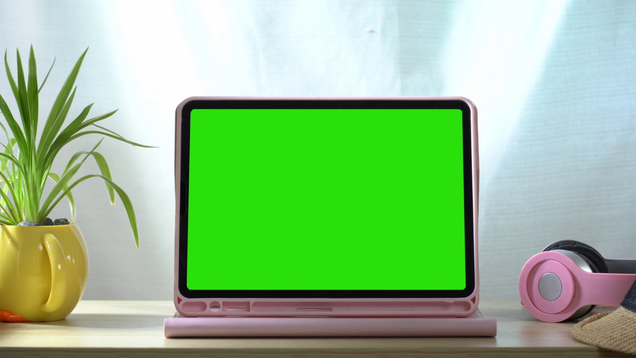 一个数字平板电脑与绿色屏幕在桌子上创建媒体。视频下载
