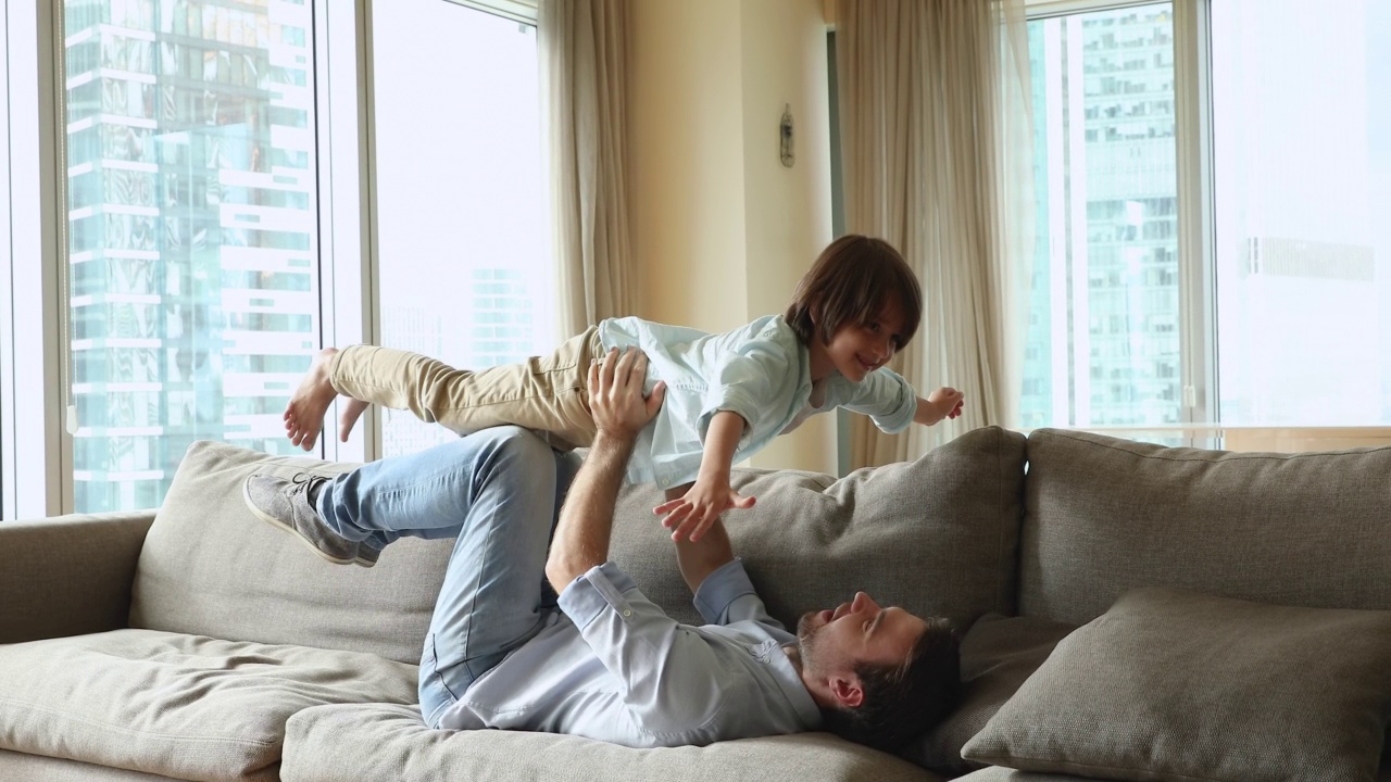 爸爸和儿子在现代的家中玩耍，享受有趣的休闲视频素材