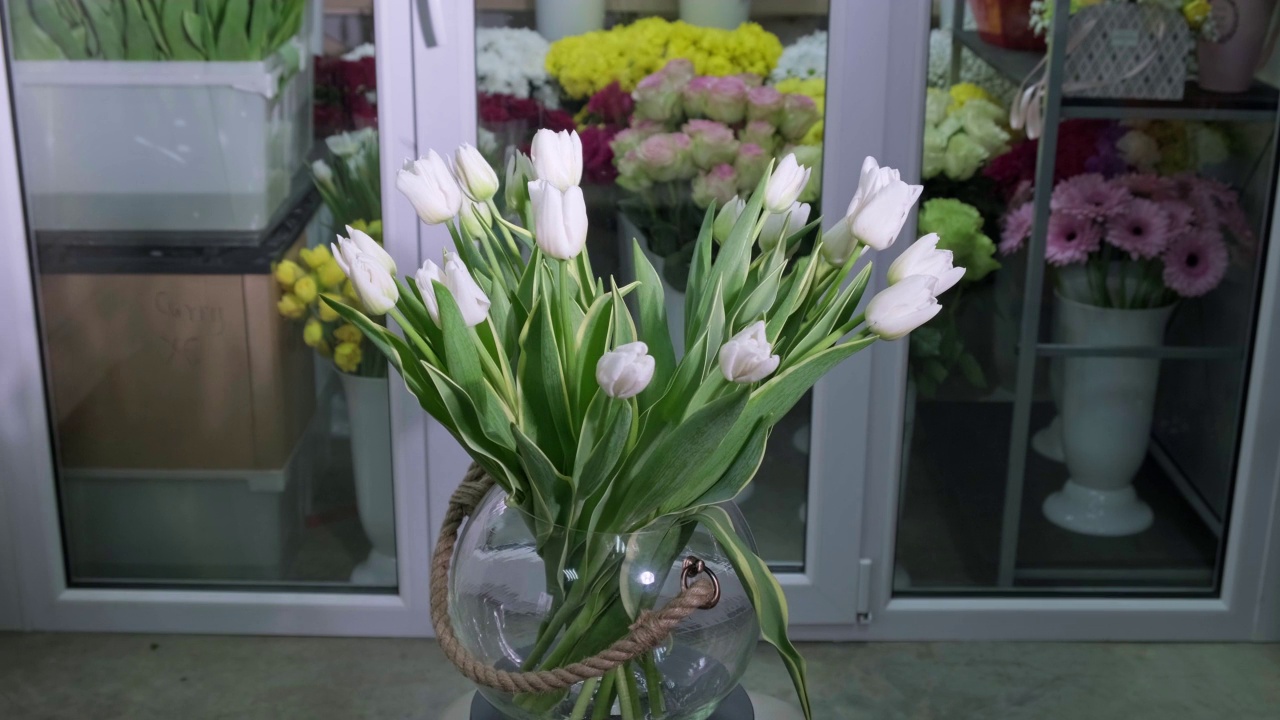 一束郁金香花在旋转的花瓶。春天的白色花朵，郁金香视频素材