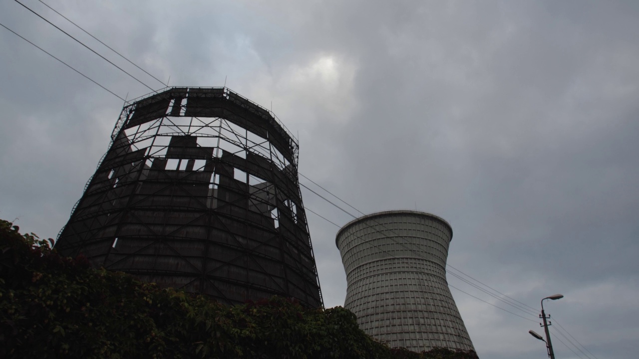 热电厂冷却塔的跟踪镜头对戏剧性的多云天空。�除了全球变暖、环境灾难和使用不可持续的燃料之外视频素材