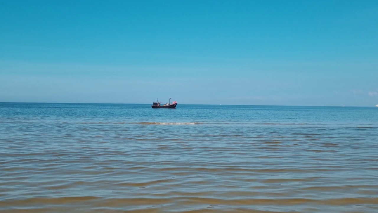 远处，一艘小渔船在海上航行视频素材