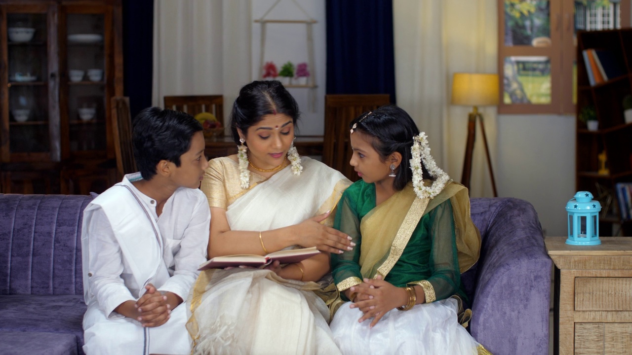 年轻的南印度兄弟姐妹和他们的母亲一起读书-一个小家庭，育儿，故事时间视频素材