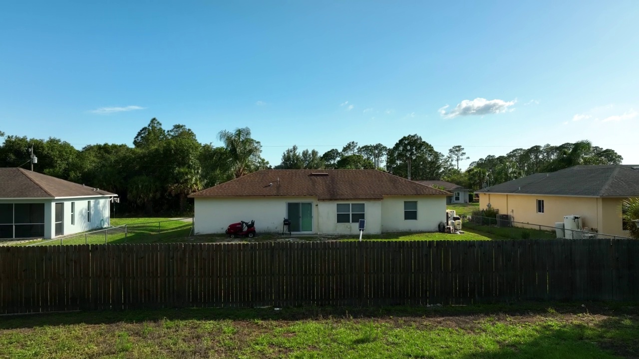 在佛罗里达州宁静的农村地区，绿色棕榈树之间的郊区私人住宅的空中景观视图视频素材