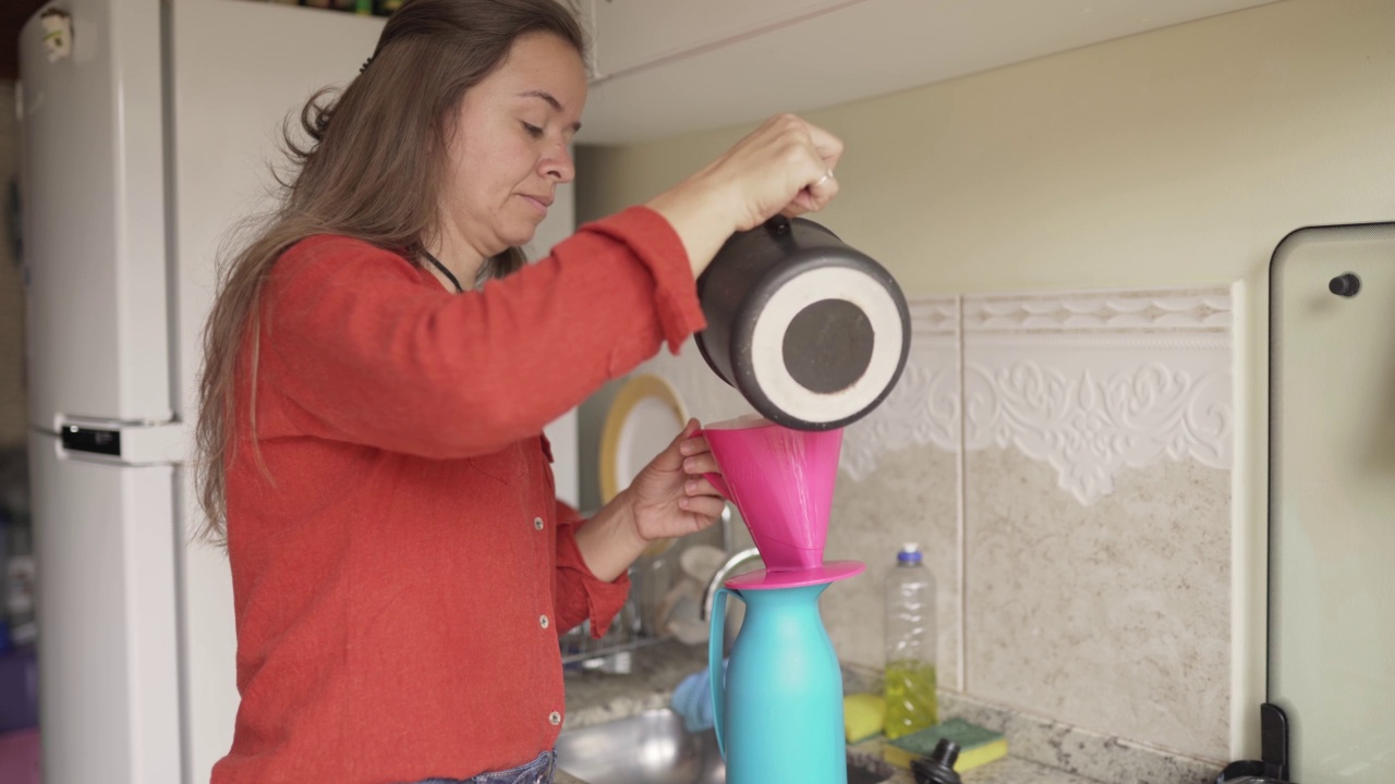一位妇女正在厨房的柜台上煮一杯新鲜的咖啡视频素材