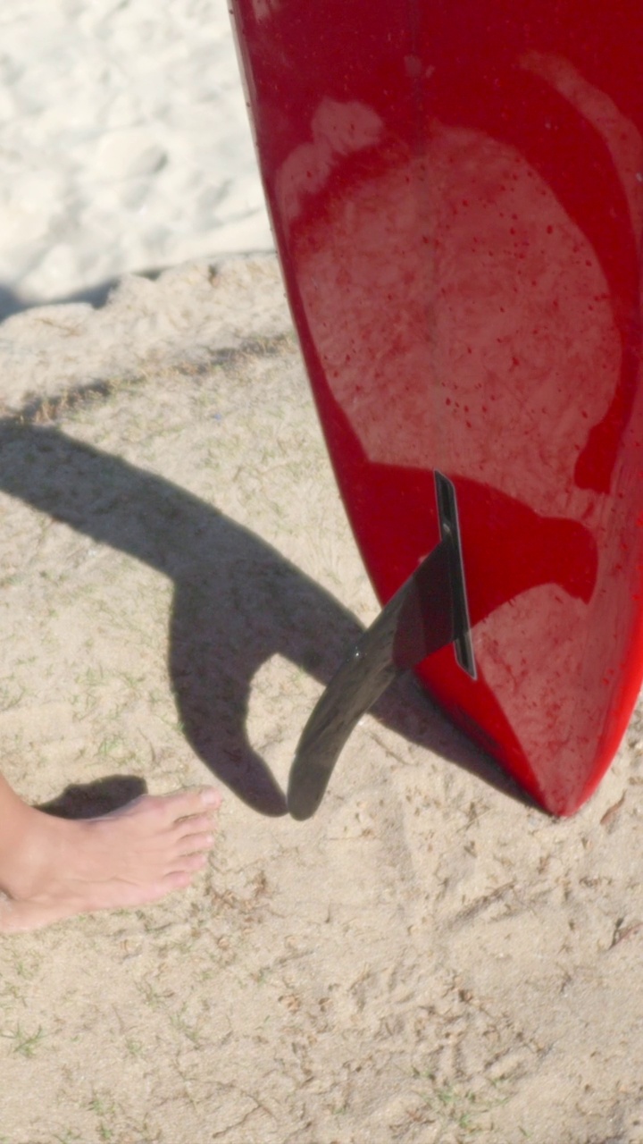 红色冲浪板与黑色的鳍skeg特写细节。- - - - - -垂直格式视频下载