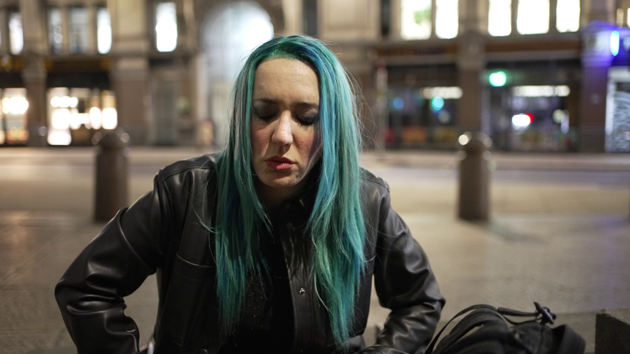 外面有一幅蓝色头发，情绪激动，正在哭泣的年轻女子的画像视频素材