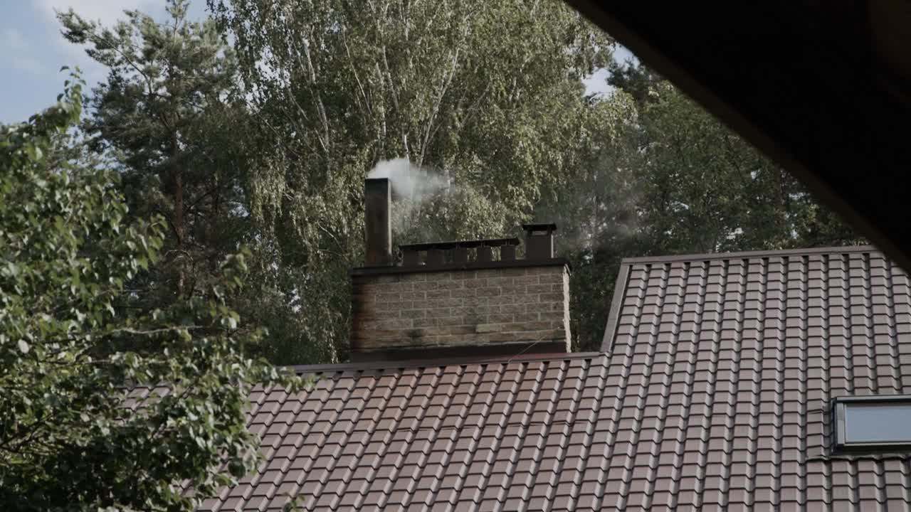 夏天，瓦屋顶的烟囱里冒出灰色的烟视频素材