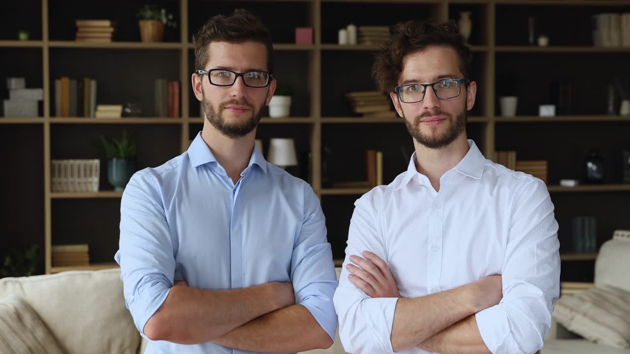 一对戴眼镜的双胞胎兄弟一起站在客厅里视频下载
