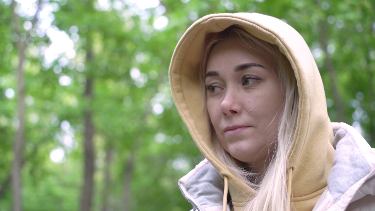 一位年轻迷人的高加索千禧一代女性在森林中若有所思地看着远处。视频素材