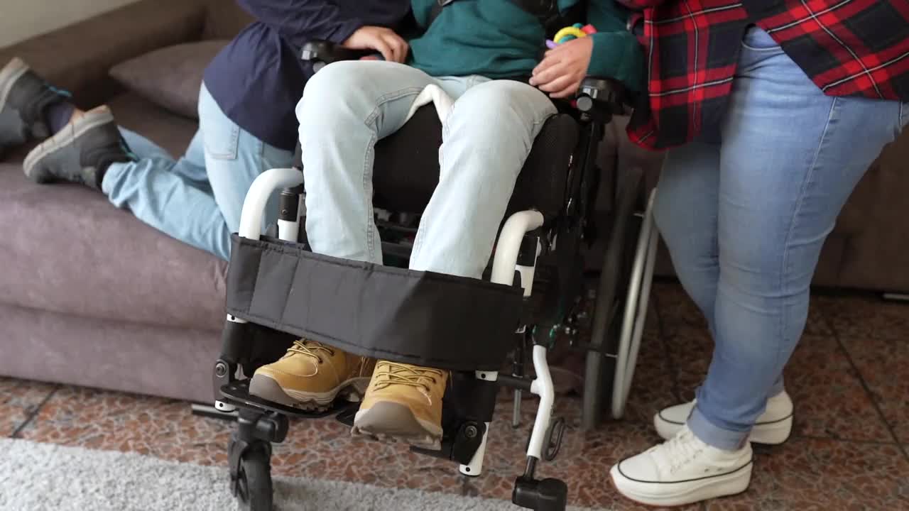 家里有一个坐轮椅的自闭症儿子，在家里的客厅里——社会问题——视频下载