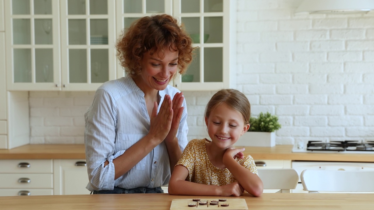 快乐的小女孩和妈妈一起玩棋盘游戏。视频下载