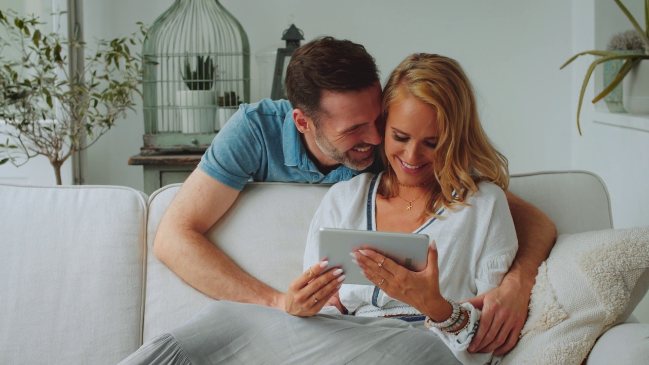 幸福的情侣看着电子平板电脑视频素材
