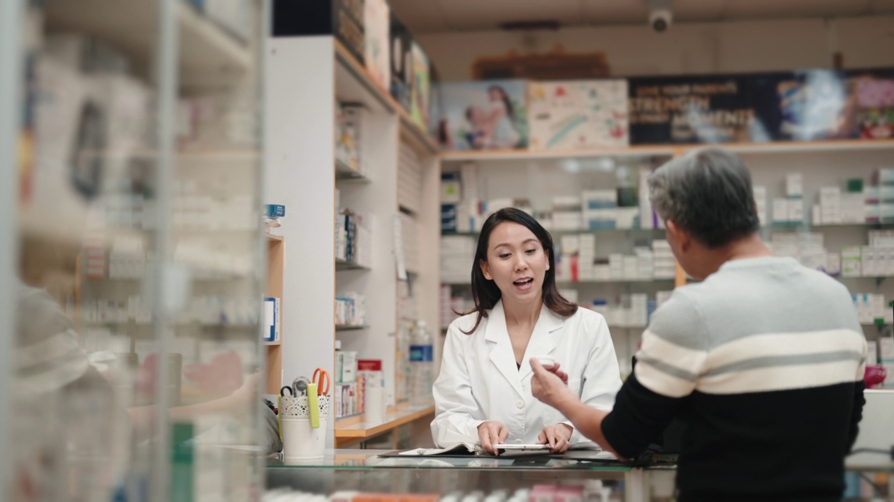 亚洲华人老年男子在药店向女药剂师寻求医疗用品方面的建议视频下载