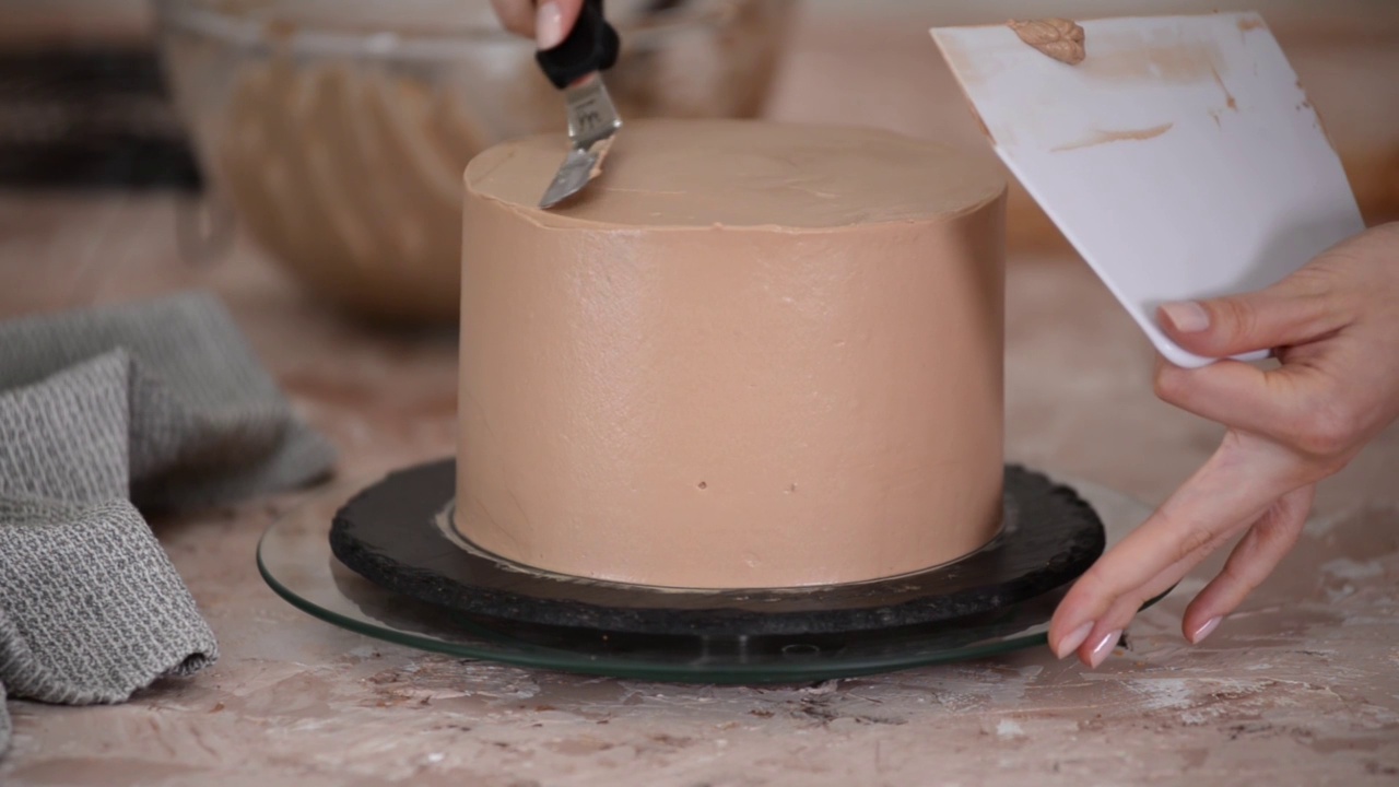 女人用巧克力奶油和饼干制作甜蛋糕的手的特写。视频下载