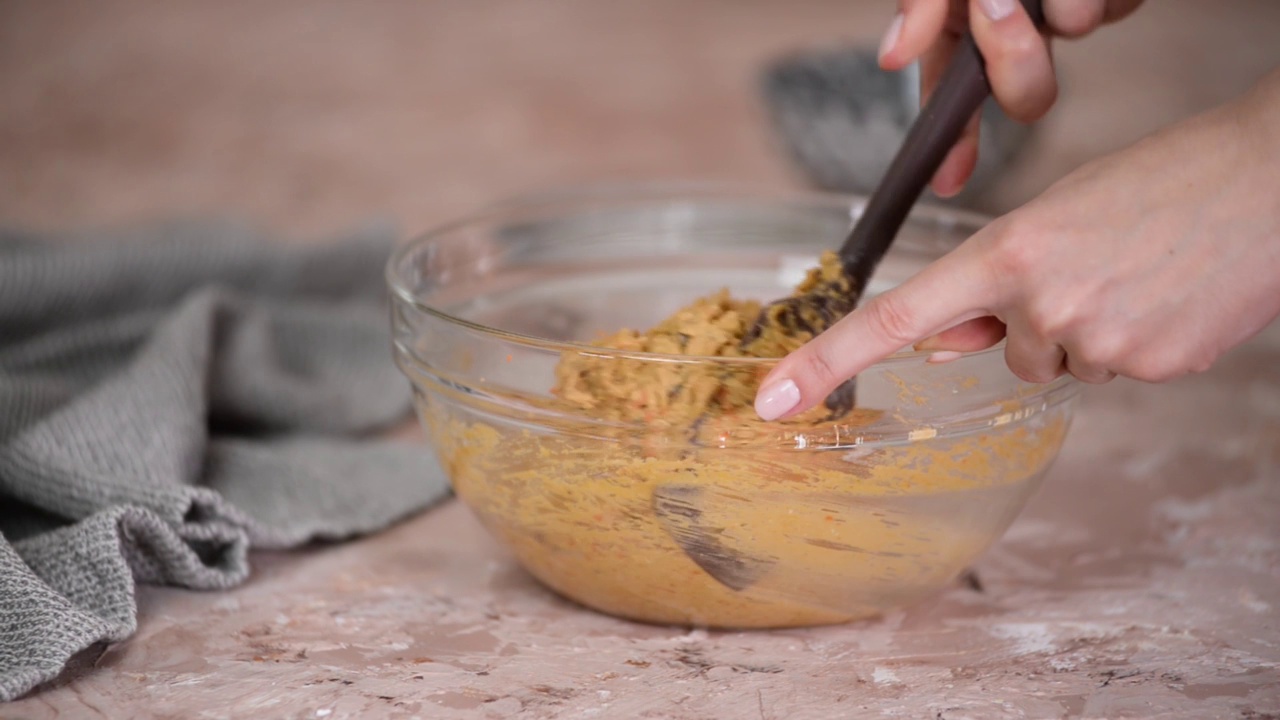 制作胡萝卜面团的过程。用橡皮刮刀搅拌面团。视频下载