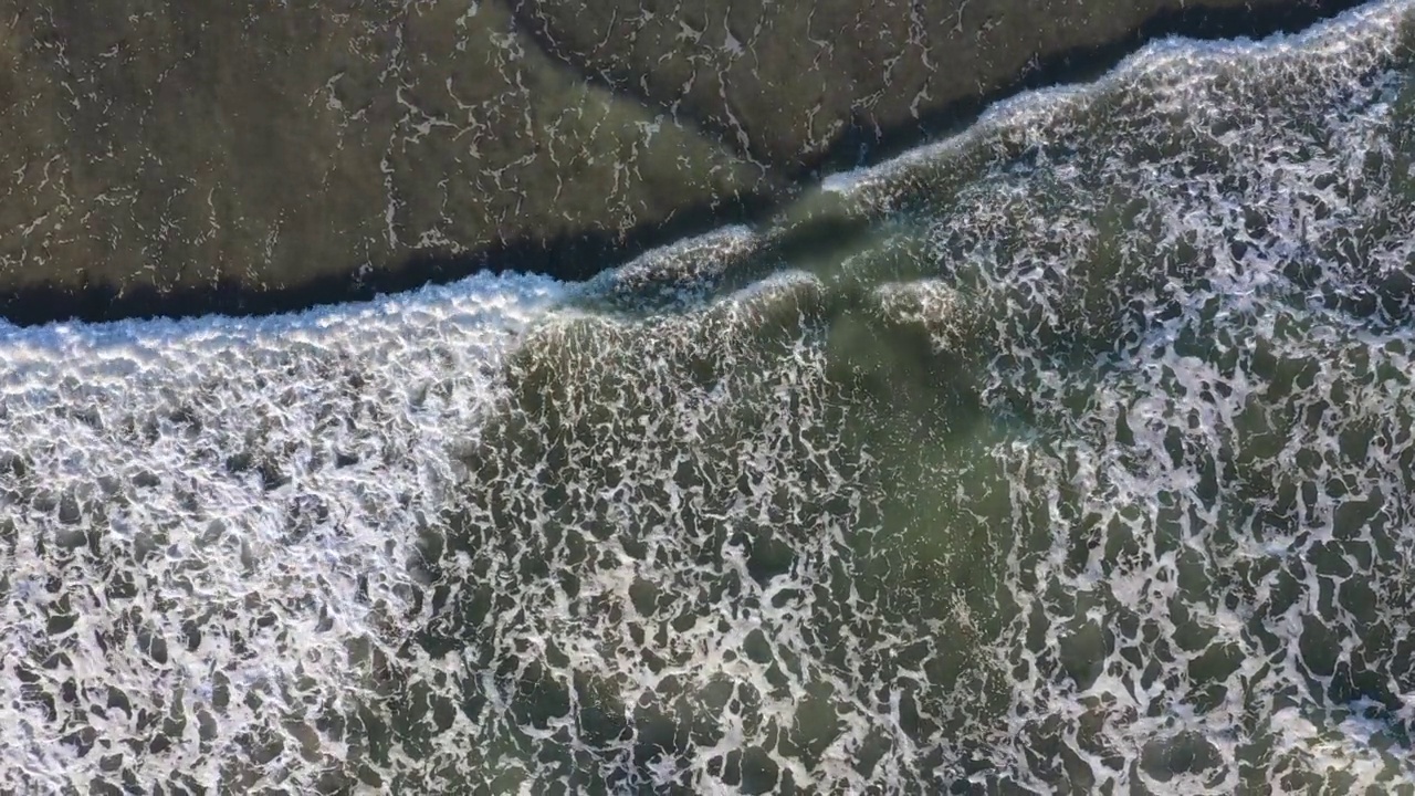 无人机在太平洋的海滩上空盘旋在海浪之上，航行到海岸线上视频素材