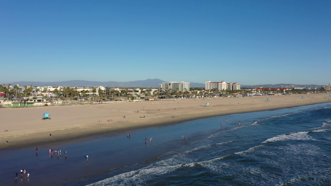 下午晚些时候，无人机在加州亨廷顿海滩面对海岸线的水上飞行视频素材