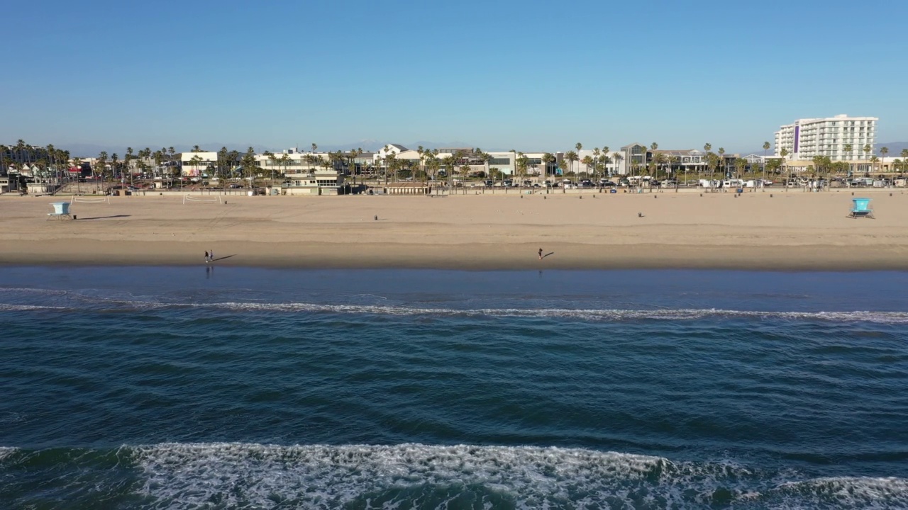 无人机盘旋在太平洋上的亨廷顿海滩加州面对海滩视频素材