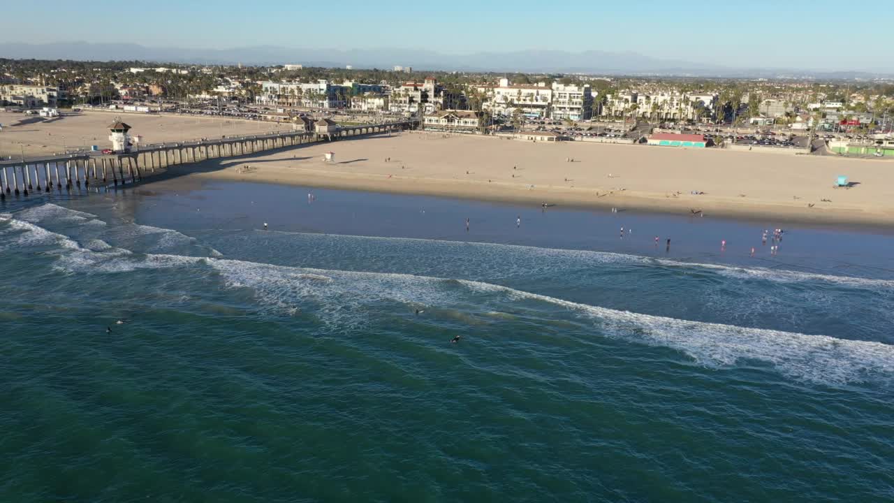 无人机盘旋在太平洋上的亨廷顿海滩加州面对海滩视频素材