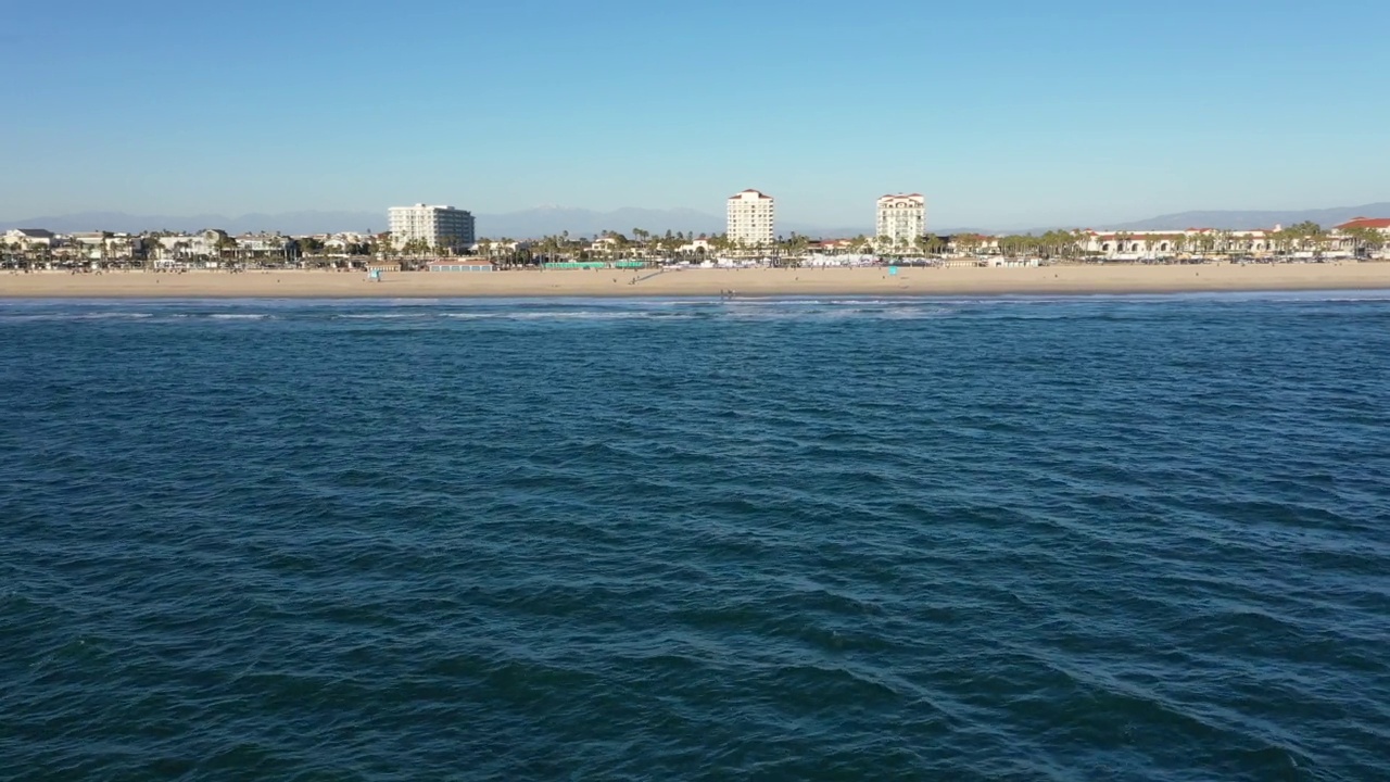 无人机在太平洋上空的亨廷顿海滩加州飞向海滩海岸线视频素材