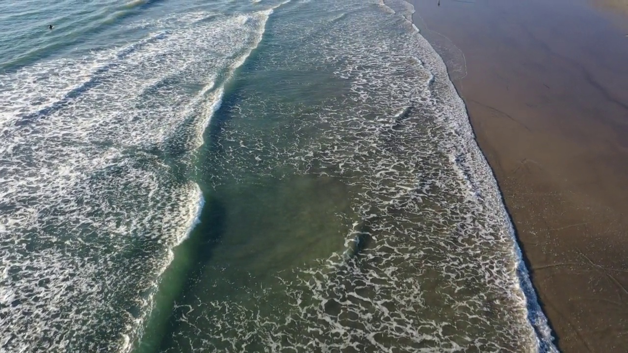 无人机与相机向下飞行平行海浪沿海滩海岸线视频素材