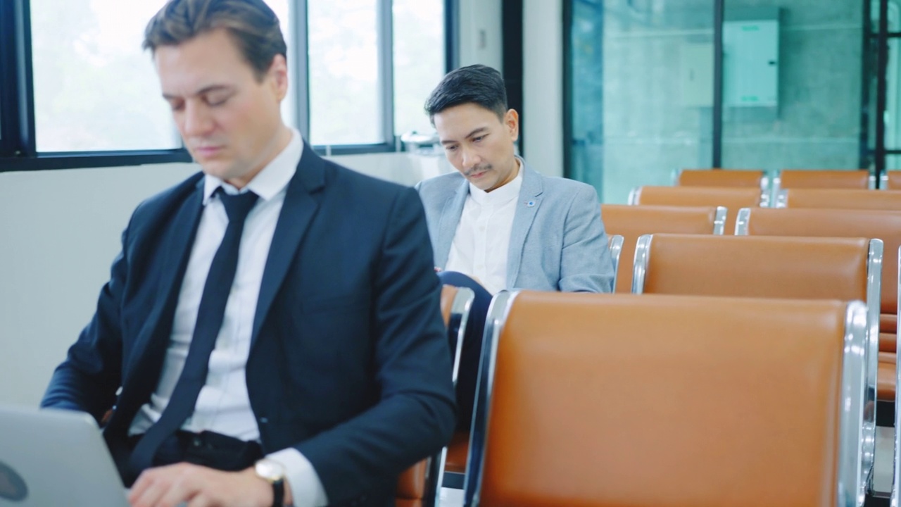 企业家在机场等候时使用笔记本电脑。视频素材