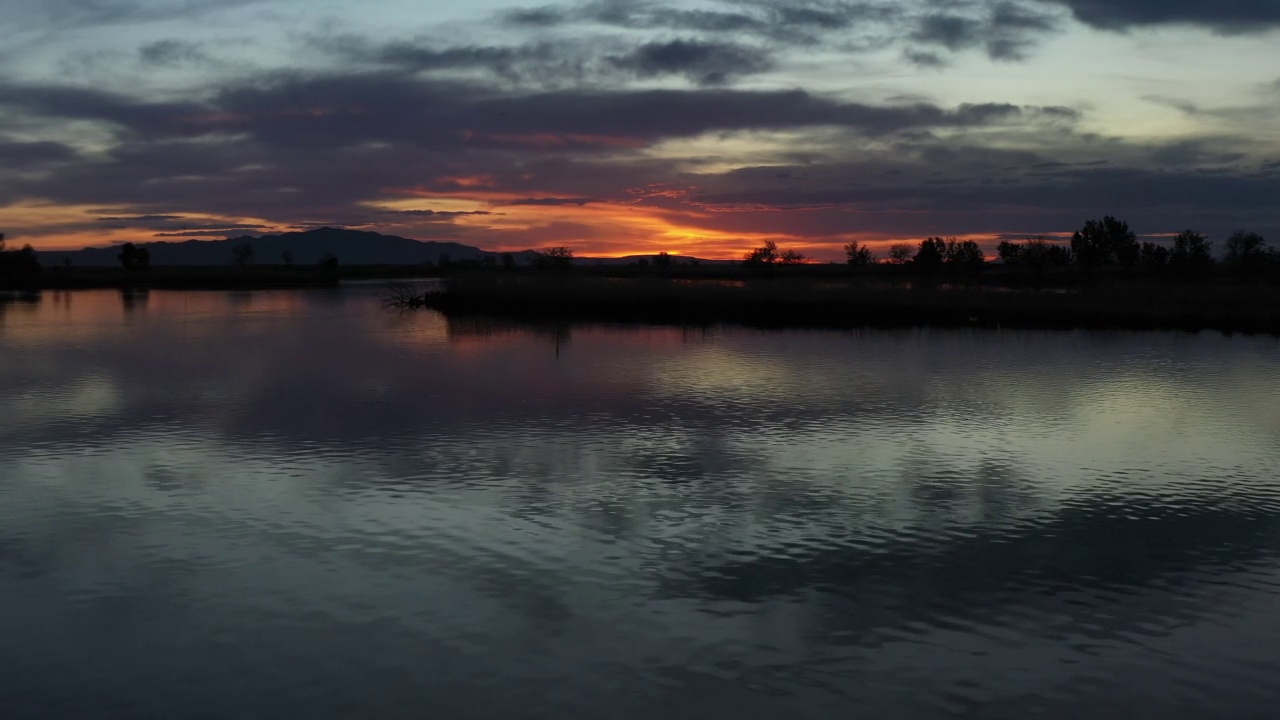 无人机在日落时快速飞过湖面视频素材
