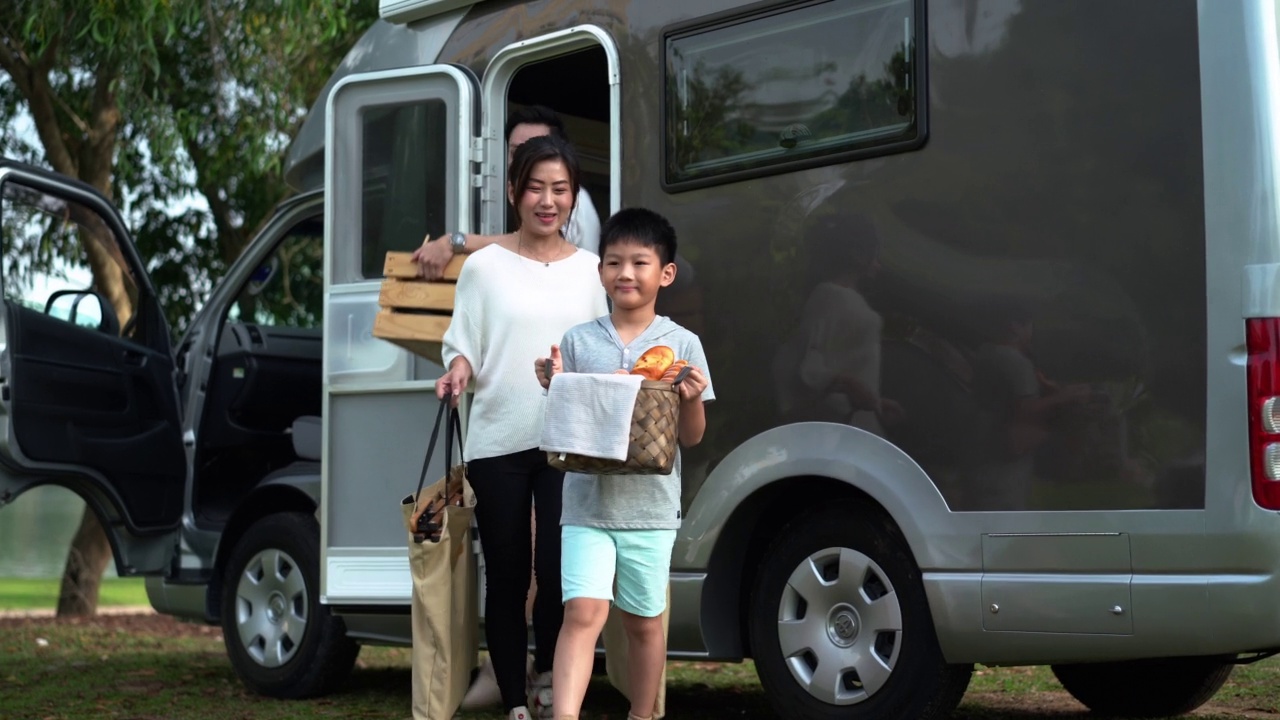 亚洲家庭在公园搭露营车野餐视频素材