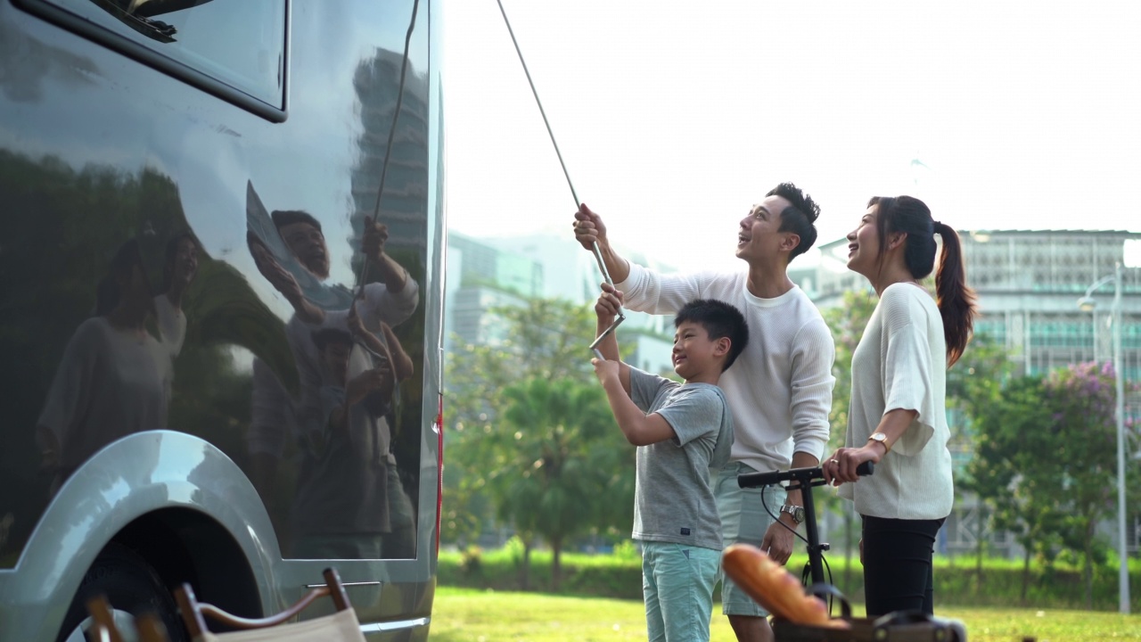 亚洲家庭在公园里搭大篷车野餐视频素材
