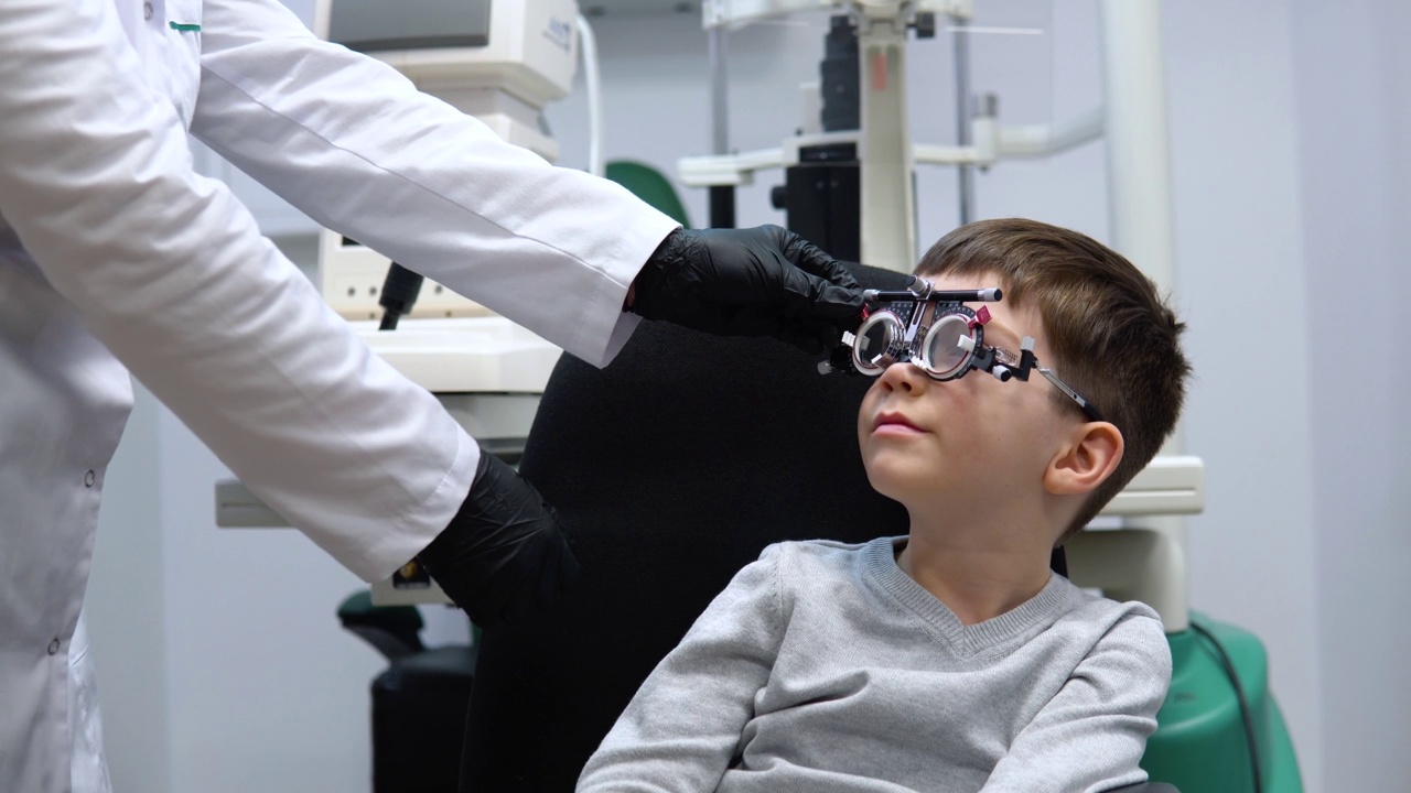 眼科医生对试镜进行调整，为男孩选择镜片视频素材