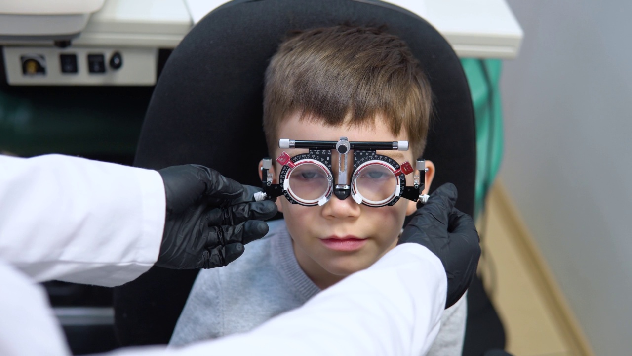 一个男孩坐在椅子上接受眼科医生的预约去取隐形眼镜视频素材