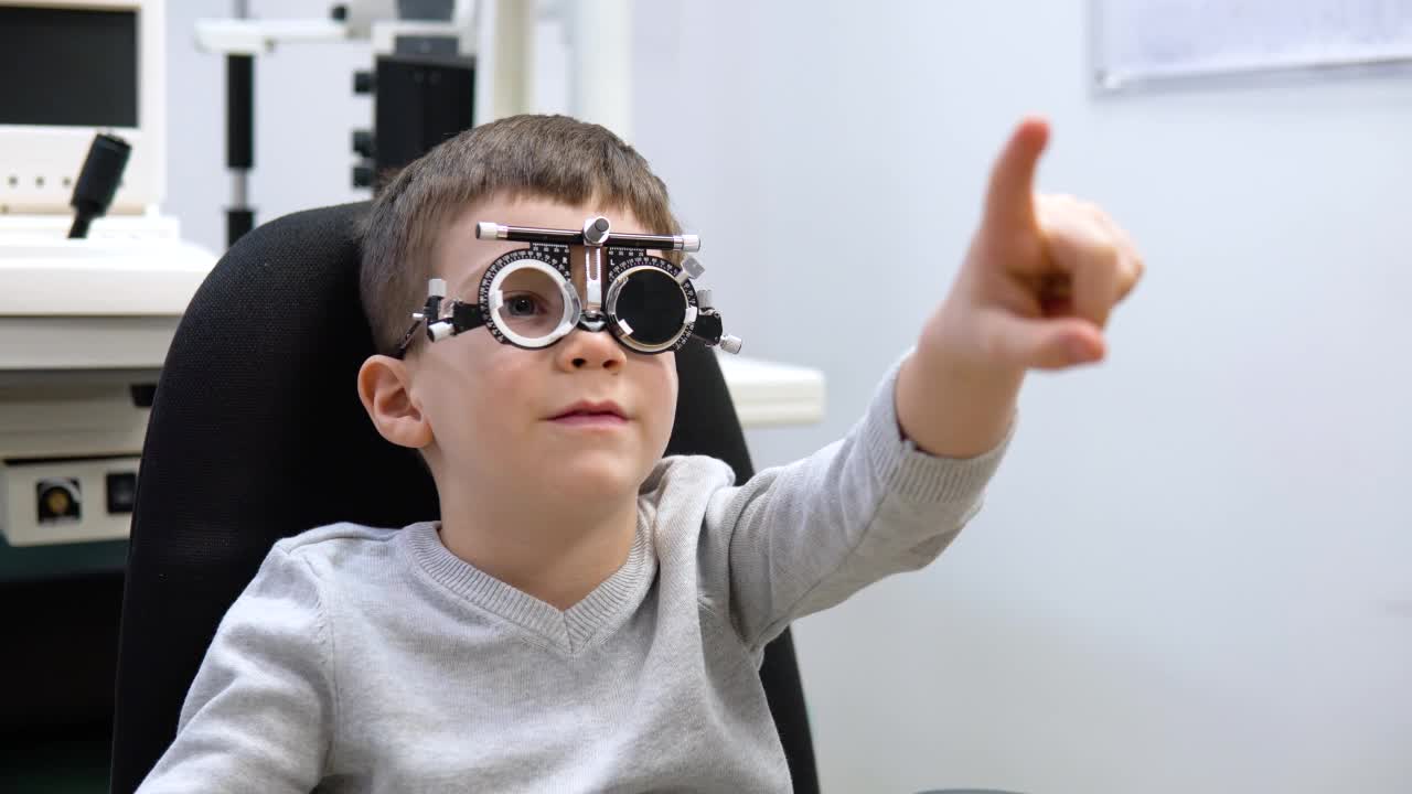 男孩坐在眼科医生办公室的椅子上检查视力视频素材