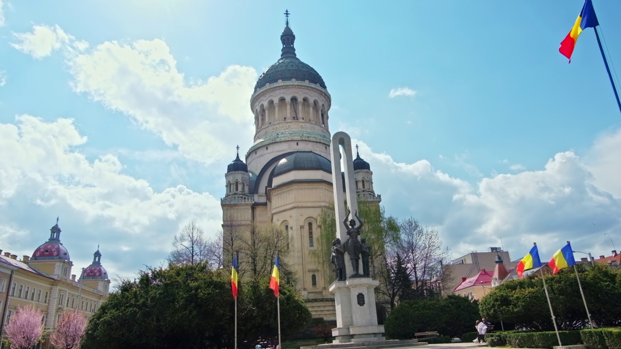 位于罗马尼亚克卢日纳波卡市中心的阿夫拉姆·扬库广场上的东正教大教堂。盛开的树在它的前面视频下载
