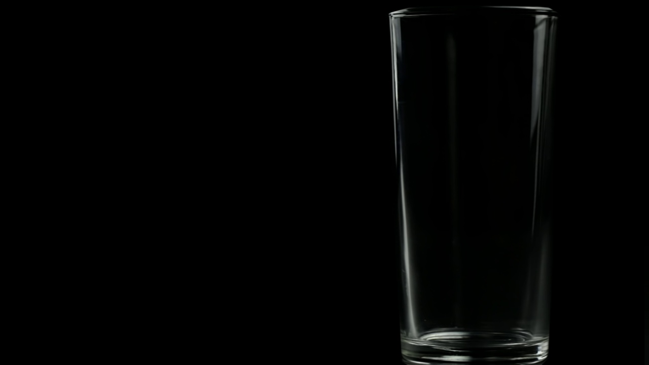 在黑色背景下喝空杯子里的果汁视频下载