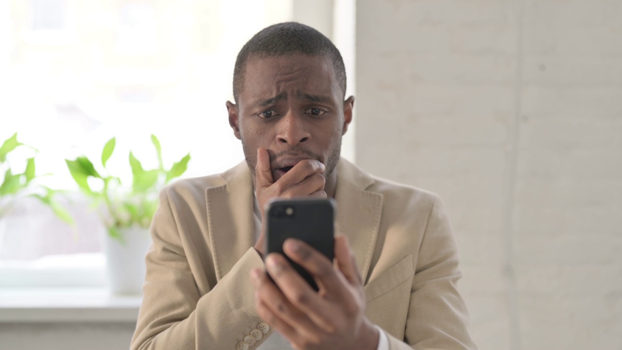 非洲男子在智能手机上对失去的反应视频素材