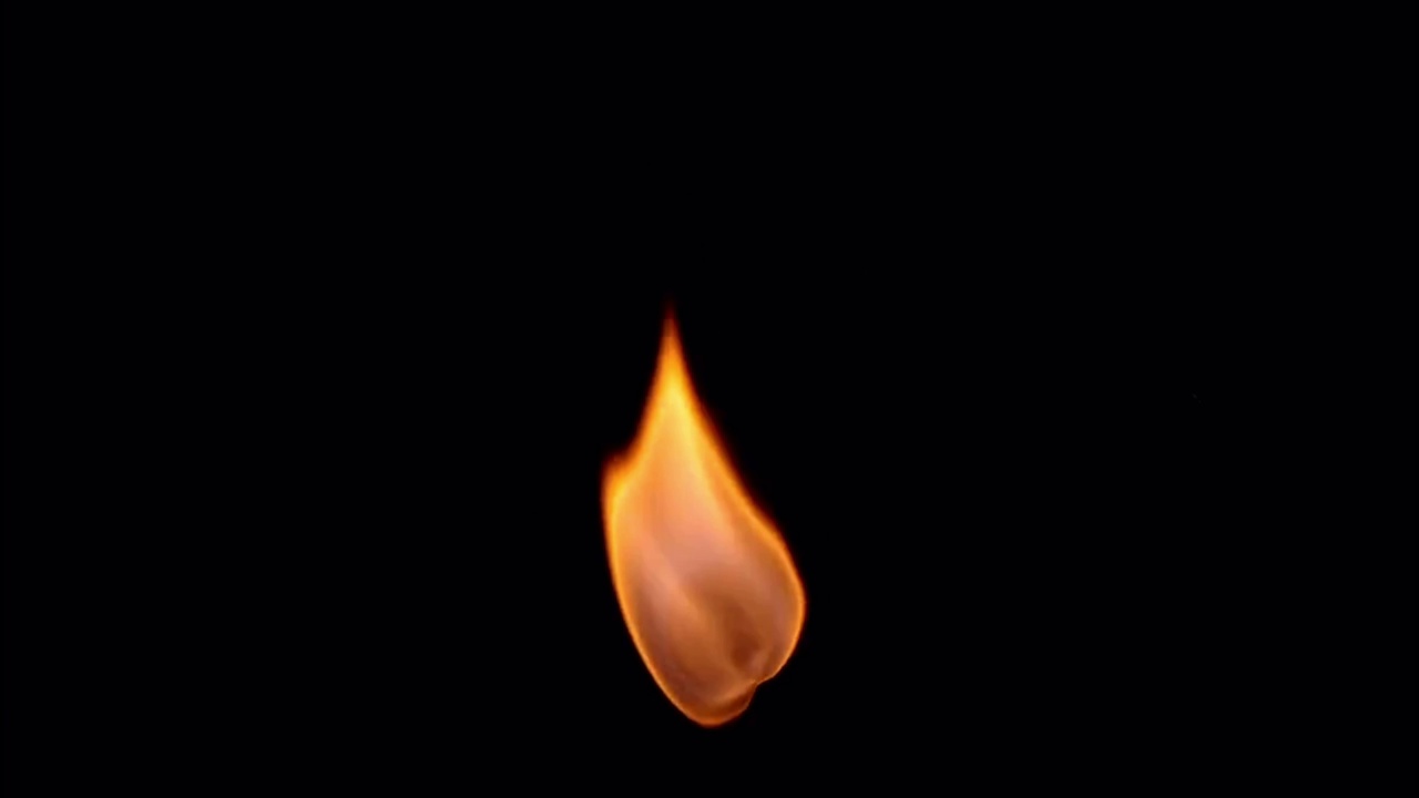 现实的橙色蜡烛火焰孤立在黑色背景。视频素材