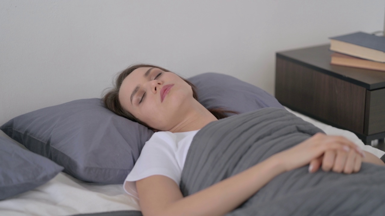 放松的女人平静地睡在床上视频素材