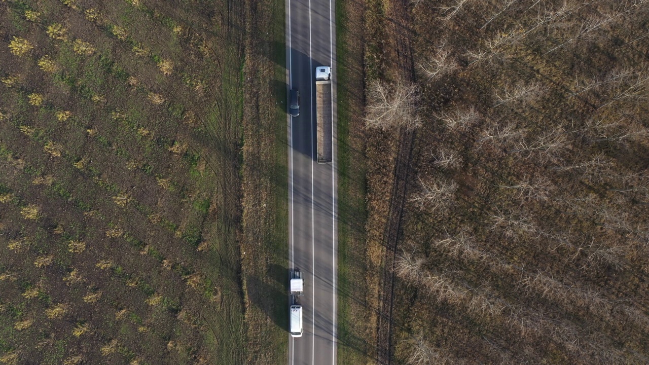 自上而下航拍各种车辆在公路上穿越乡村景观，无人机拍摄视频下载