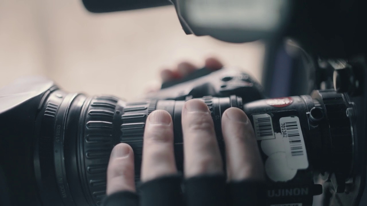 一个肩上扛着摄像机的摄影师正在拍摄一篇报道。坐在汽车的前座上拍摄视频视频素材