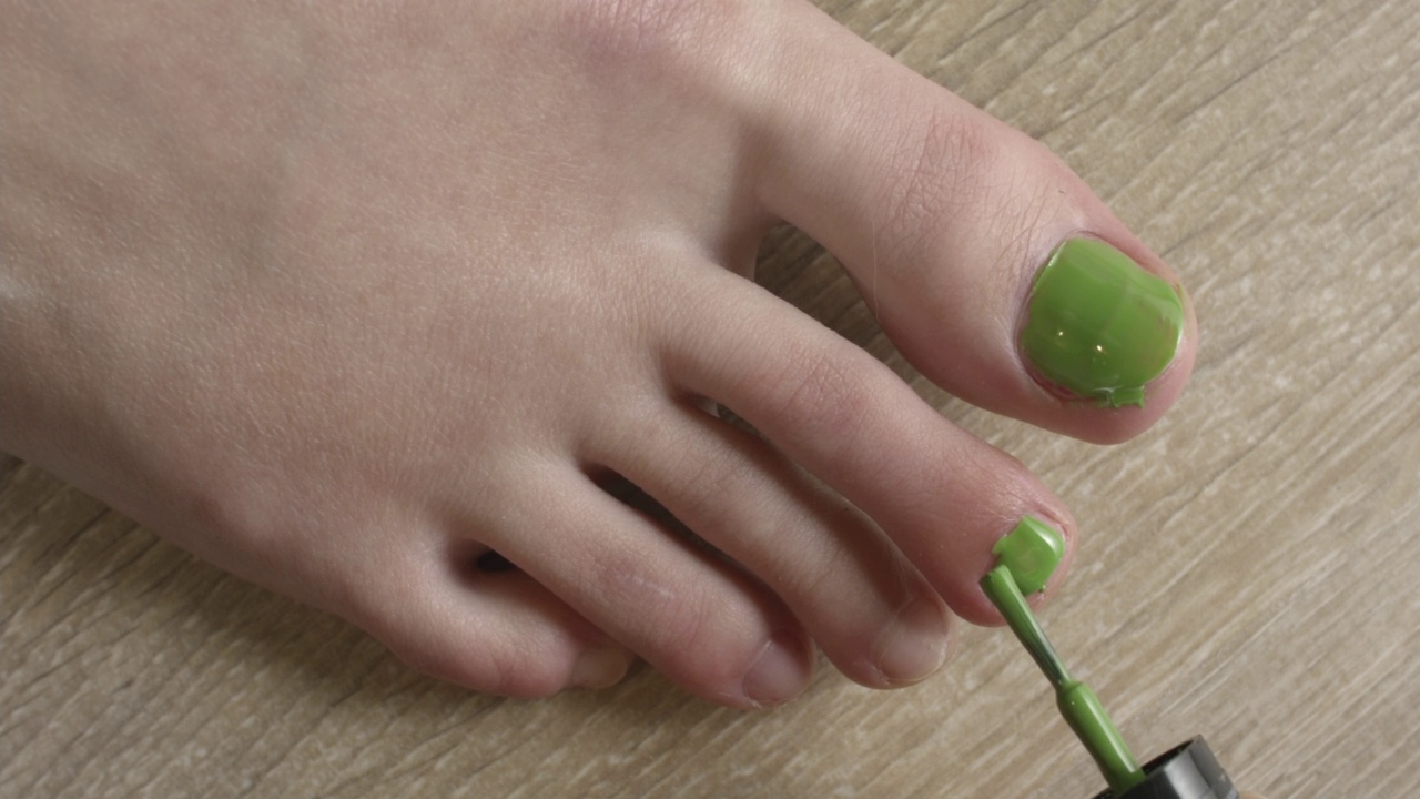 一个年轻女人涂脚趾甲的特写。视频素材