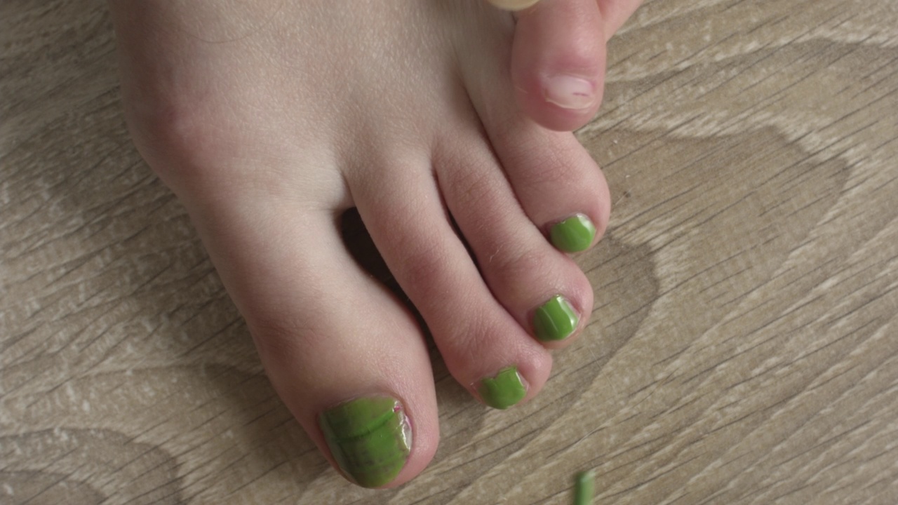 一个年轻女人涂脚趾甲的特写。视频素材