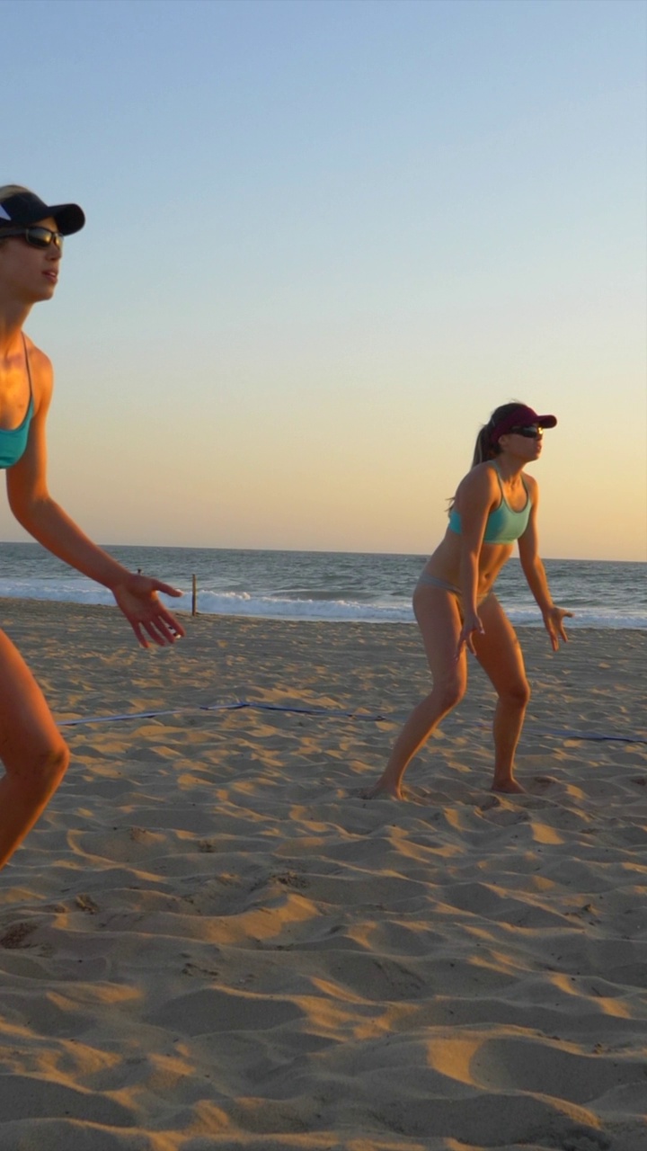 沙滩排球女子运动员发球接球传球。-垂直格式-慢动作视频下载