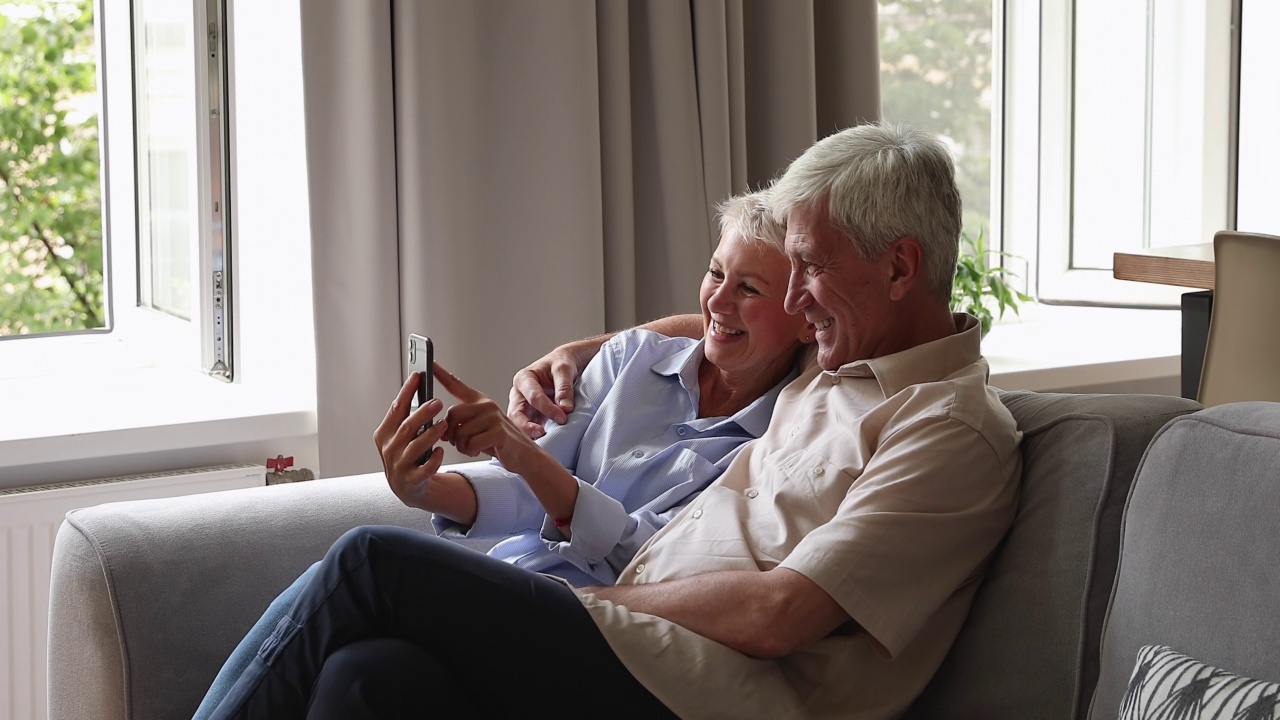 兴奋的老夫妇祖父母用智能手机视频通话视频素材