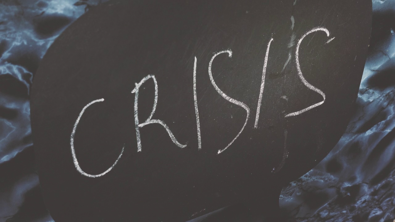 男人的手打开了一个写着“危机”的空冰箱，拿了一个青苹果。概念4k原始视频。经济危机，食物短缺，贫穷。视频下载